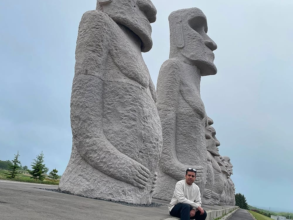 Large moai-style stone statues at a hillside site in Japan